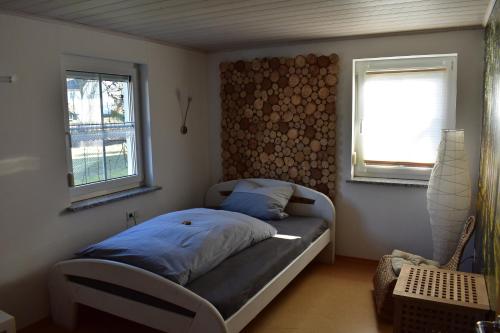 a small bedroom with a bed and two windows at Zimmer Bärbel in Förbau