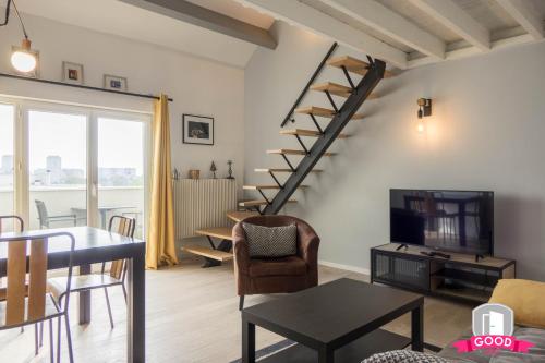 a living room with a spiral staircase and a table at Le Duplex Ensoleillé du Parc * Parking * Balcon * in Orléans