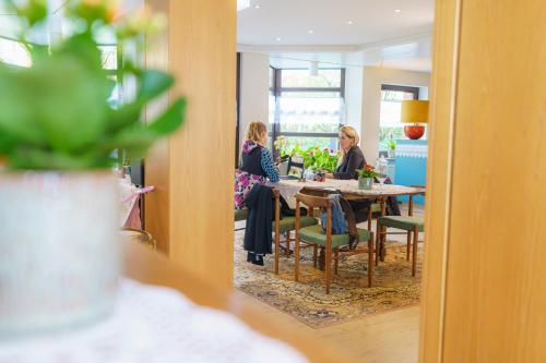two women sitting at a table in a dining room at Tante ALMA's Bonner Hotel in Bonn