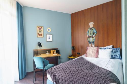 Tante ALMA's Bonner Hotel في بون: غرفة نوم مع سرير مع اللوح الأمامي الخشبي ومكتب