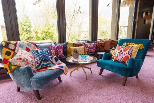 a living room with two chairs and a couch with pillows at Tante ALMA's Bonner Hotel in Bonn