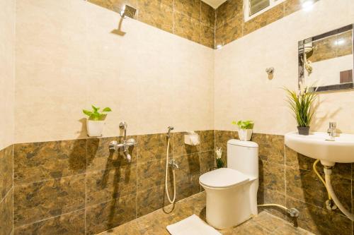 a bathroom with a toilet and a sink at Hotel Signature Airport Zone Shamshabad Hyderabad in Hyderabad