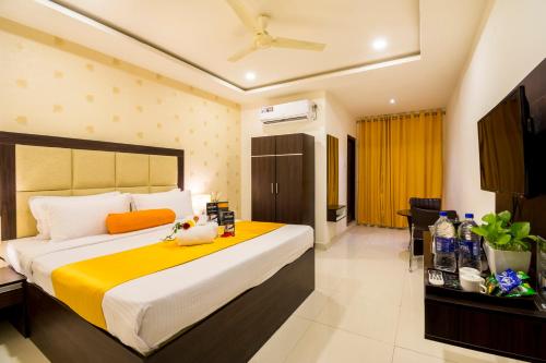a hotel room with a large bed and a television at Hotel Signature Airport Zone Shamshabad Hyderabad in Hyderabad