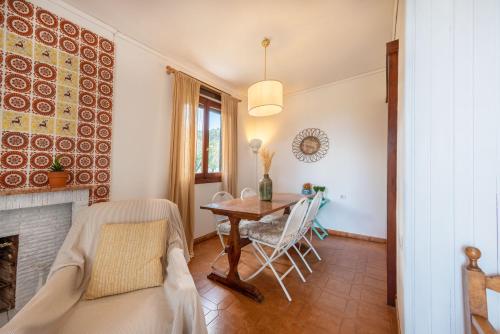 a living room with a dining room table and a fireplace at To Ktimataki in Agios Gordios