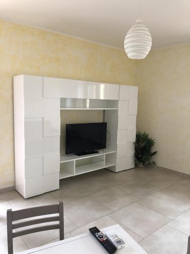 a living room with a tv and a white wall at Villa Giantonia in Minturno