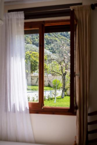 a window with a view of a garden outside at To Ktimataki in Agios Gordios
