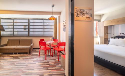 een hotelkamer met een bed en een tafel en stoelen bij Ben Yehuda Apartments in Tel Aviv