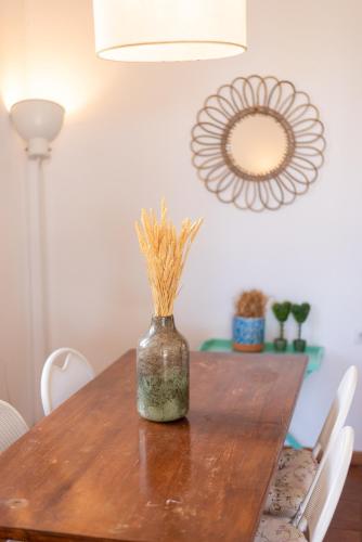 a wooden table with a vase with grass in it at To Ktimataki in Agios Gordios