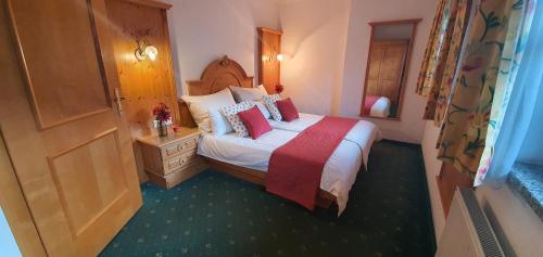 a hotel room with a bed with red pillows at Schlosserhaus Appartements in Wagrain