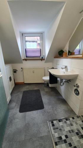 an attic bathroom with a sink and a window at Ferienwohnung Elsa in Hungen