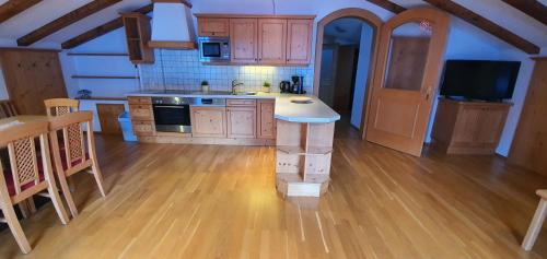 a kitchen with wooden cabinets and a table in a room at Schlosserhaus Appartements in Wagrain