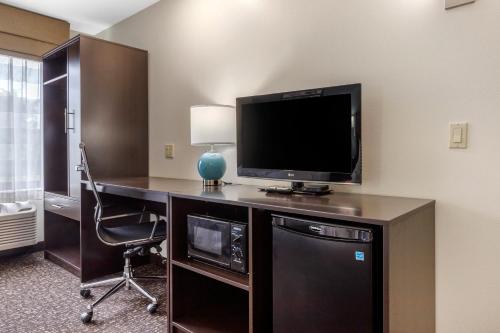 a room with a desk with a television and a chair at Sleep Inn & Suites in Johnson City