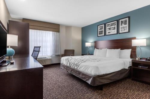 a hotel room with a bed and a desk at Sleep Inn & Suites in Johnson City