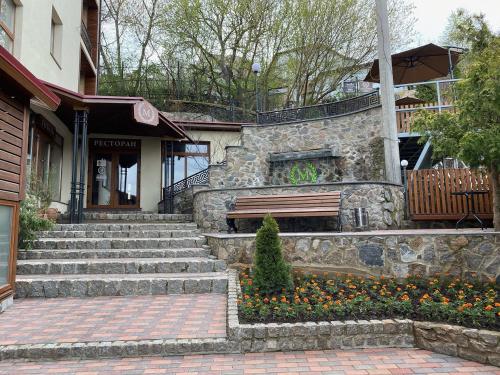 a stone building with a bench in front of a building at Melania in Umanʼ