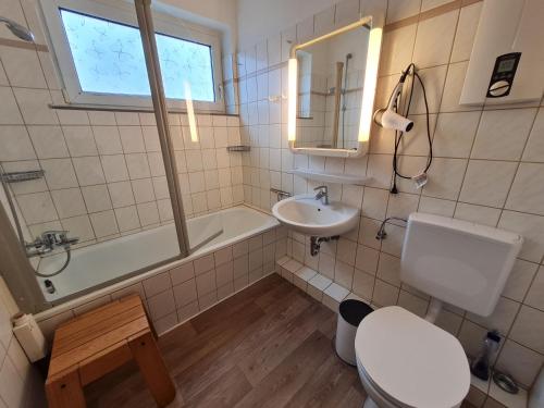 ein Badezimmer mit einem WC, einem Waschbecken und einer Badewanne in der Unterkunft Wattwurm in Wyk auf Föhr