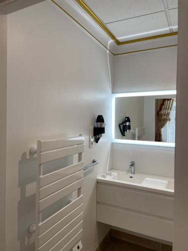 ein Bad mit einem Waschbecken und einem Spiegel in der Unterkunft Chambre Lyre Maison de L'Église du Couvent in Narbonne