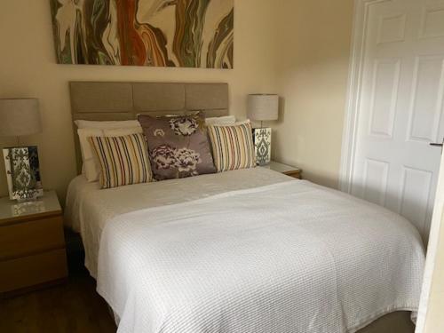 a bedroom with a large white bed with pillows at Crossways Tavern in Exeter