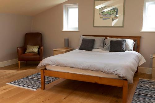 a bedroom with a large bed and a chair at Garden Villa in Cambridge