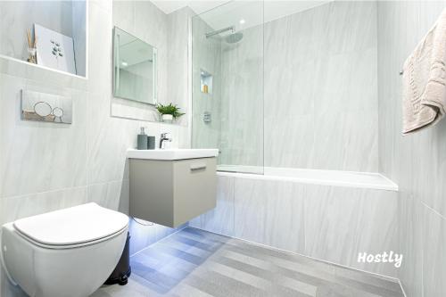 a bathroom with a toilet and a sink and a tub at Vanburgh Court Apartments in Slough