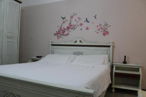 ein Schlafzimmer mit einem Bett mit Blumen und Vögeln an der Wand in der Unterkunft La casa sulla dolina in Campoli Appennino
