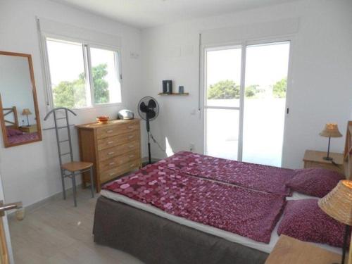 sypialnia z łóżkiem, komodą i oknami w obiekcie Casa-Zinat w mieście Calpe