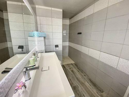 une salle de bain blanche avec un lavabo et un miroir dans l'établissement Villa La Guapa, sea view, private pool, 5 min from the beach, à Oyster Pond
