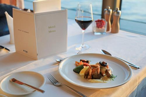 a plate of food on a table with a glass of wine at VIVA RIVERSIDE Altstadt Düsseldorf in Düsseldorf