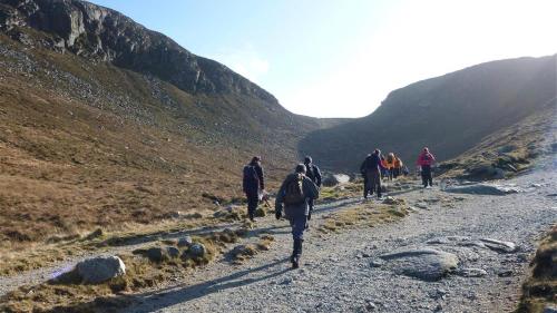 a group of people walking down a mountain road at Rostrevor Mountain Lodge - Glamping Pods - Revive Sauna & Hot Tubs in Rostrevor
