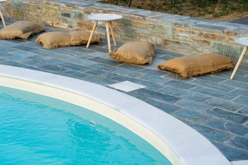 a row of pillows sitting next to a swimming pool at Anassa Cycladic Village in Galissas