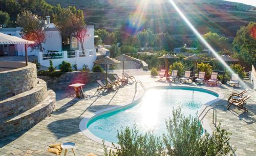 a swimming pool with tables and chairs in a resort at Anassa Cycladic Village in Galissas