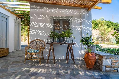 a patio with a table and chairs next to a wall at Anassa Cycladic Village in Galissas