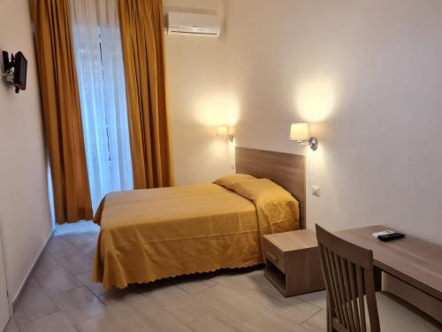 a hotel room with a bed and a desk at Albergo Enrica in Rome