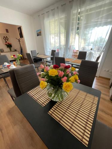 a dining room with a table with a vase of flowers on it at Agriturismo Soleada in Ventimiglia
