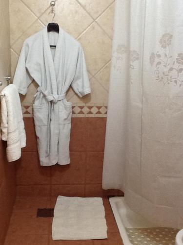 a robe and towels on a rack in a bathroom at Hipolito Argentina in Buenos Aires