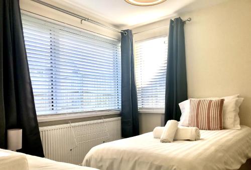- une chambre avec un lit doté de rideaux bleus et d'une fenêtre dans l'établissement 16 Beatrice Avenue, à Shanklin