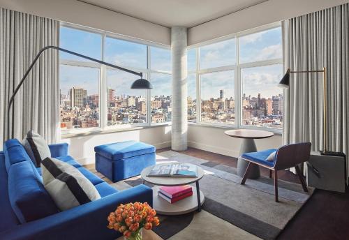 a living room with a blue couch and a large window at ModernHaus SoHo in New York