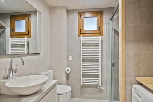 a bathroom with a sink and a toilet and a shower at Luderna - Apartamento Des Puis in Gessa