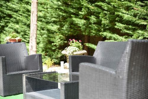 a patio with two chairs and a glass table at Château de Passières in Chichilianne