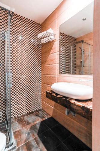 a bathroom with a sink and a shower and a mirror at Hotel A44 in Tetouan