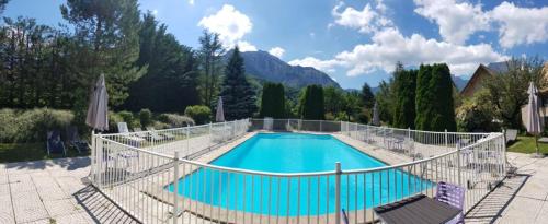 une grande piscine entourée d'une clôture. dans l'établissement Château de Passières, à Chichilianne