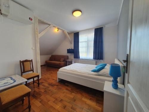 a room with a bed and a chair in it at Dworek u Leszczyńskich in Gościszewo