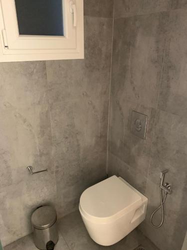 a bathroom with a white toilet and a cabinet at Petinaros Hotel in Mýkonos City