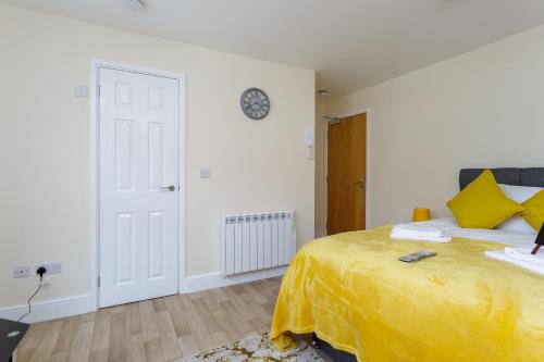 una camera da letto con un letto con una coperta gialla sopra di St Mary's - Modern Central Huge Studio Apartments a Southampton