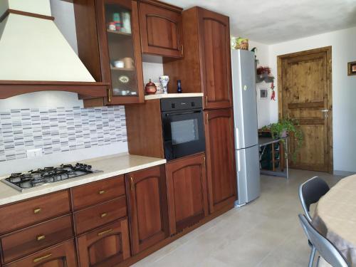 a kitchen with wooden cabinets and a stove top oven at Casa con piscina 2 Camere da letto Profumo Sea & Sun 2A in Triscina