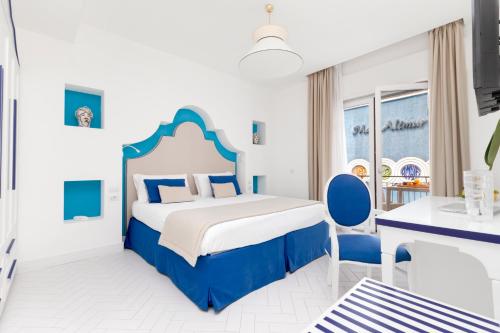 a blue and white bedroom with a bed and a desk at Alimuri Bay Resort in Meta