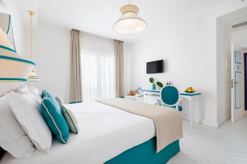 a white and blue bedroom with a bed and a desk at Alimuri Bay Resort in Meta