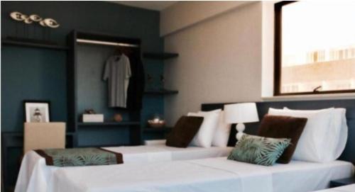 a bedroom with two beds with white sheets and green walls at Hotel do Mar Cabo Branco in João Pessoa