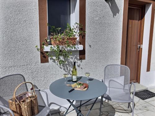 a table with a plate of food and a bottle of wine at Logis Hôtel du Cygne in Bracieux