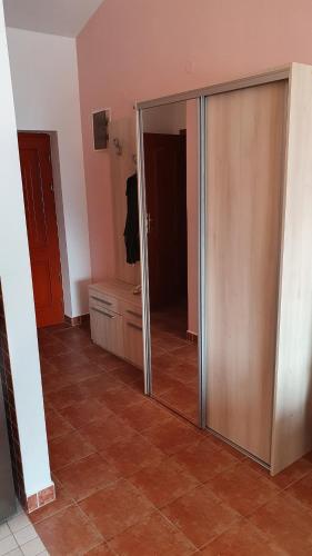 a sliding glass door in a room with a mirror at Sunrise Apartment in Baošići