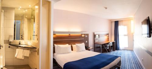 a hotel room with a bed and a bathroom at Hôtel Marseille Centre Gare Saint-Charles in Marseille
